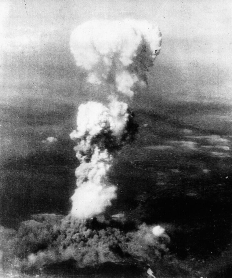 Superheated air from the detonation of the atomic bomb pushes upward in a characteristic “mushroom” cloud over the Japanese city of Hiroshima.