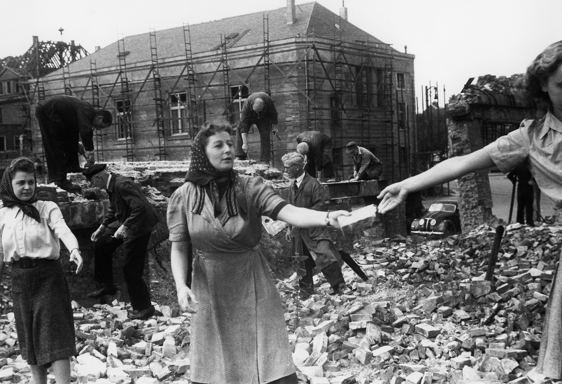 Despite widespread destruction, Hamburg citizens pitch in to clean up the damage as best they can. With most men serving in the military, women did much of the clean-up after bombings. 