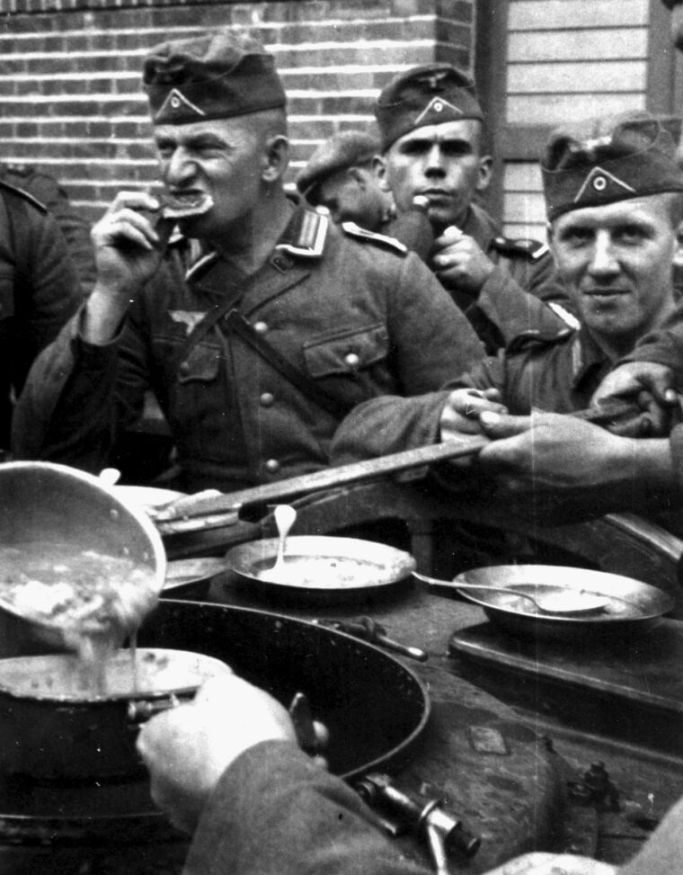 MOBILE MUNCHING: A server ladles out a liquid repast as soldiers at a mobile kitchen display a variety of expressions.
