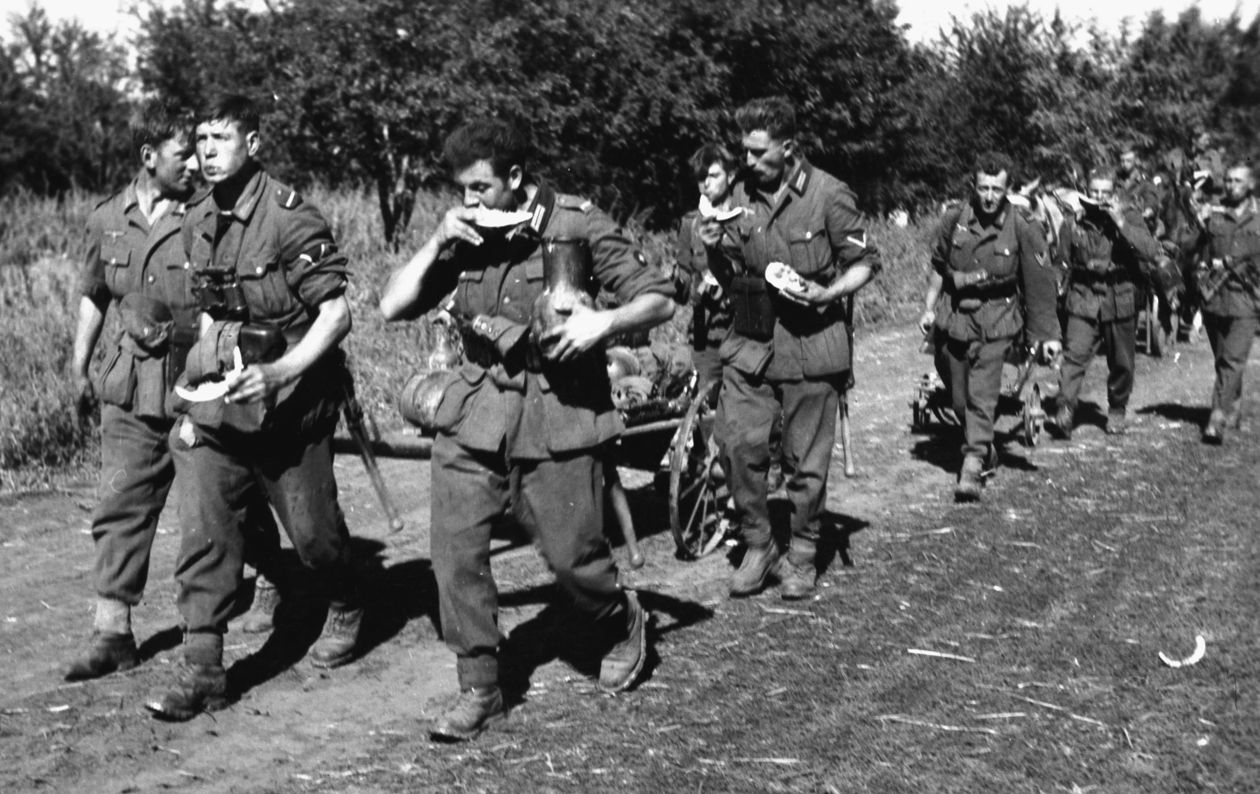 PHOTO 4: WATERMELONS FOR THE WEHRMACHT: During a hot summer day in Russia, infantry troops have apparently liberated a watermelon field (and a farmer’s cart as well) as they carry and eat their booty on the march. Like so many armies before them, the German Army was, in large part, instructed to “live off the land” when supplies could not reach them—especially in the early days of the invasion of the Soviet Union when the rapid advances outstripped slower moving wagon trains. 