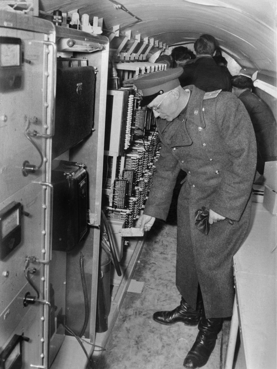 A Soviet officer shows reporters CIA electronic monitoring equipment during a press conference revealing the existence of the tunnel.