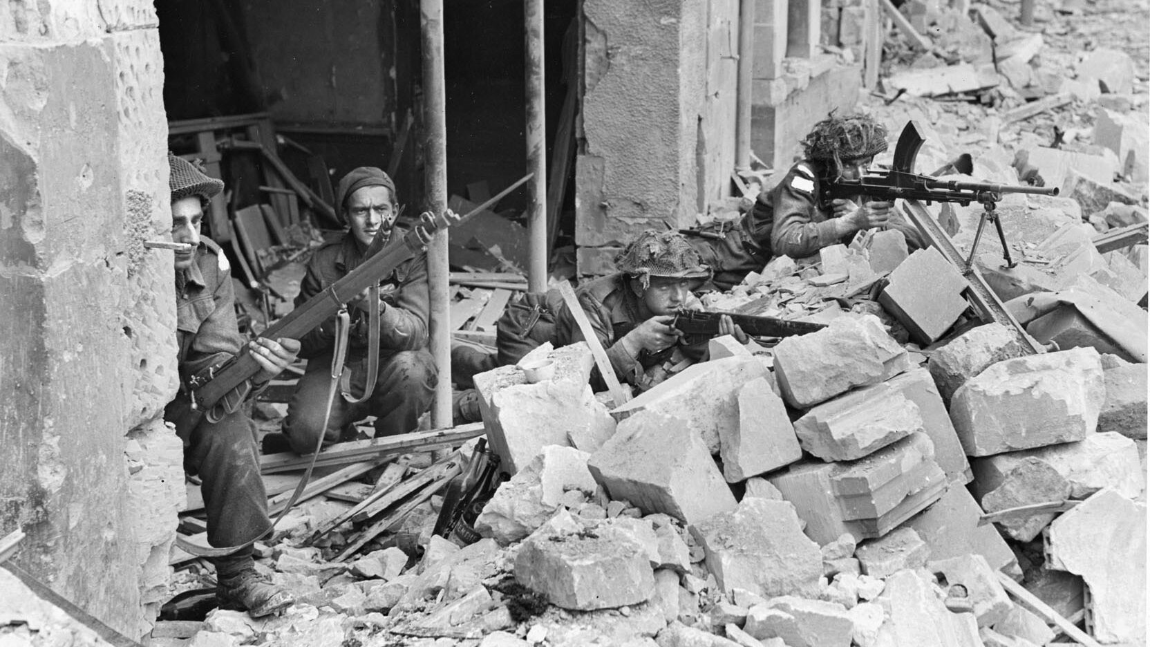 Fighting was intense in the towns and villages behind Juno Beach. Here, 3rd Canadian Infantry Division soldiers defend their position in a French town. Three of the soldiers are equipped with Lee Enfield Mk I rifles while the soldier at right is firing a Bren .303 Mk II machine gun.