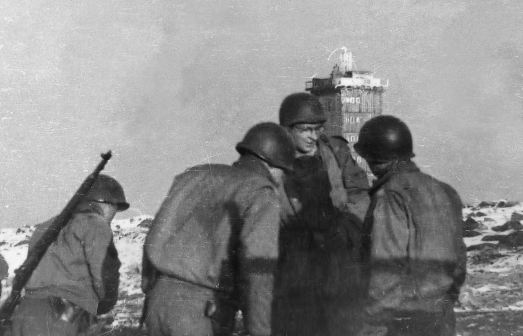 Troops of the 809th gather near the weather station tower (background) atop Brocken Peak, May 1, 1945. (The weather station is near the world’s first television transmission and radar tower, built in 1935; it transmitted broadcasts of the 1936 Summer Olympics from Berlin.) The capture of the peak was one of the last battles of the war in the ETO, and was the last combat action for the battalion. Brocken Peak is the highest point in the Harz Mountains (north-central Germany) at an elevation of 3,743 feet. Although other installations on the peak were destroyed in an April 17 Allied bombing raid, the tower survived intact and remains there today. 
