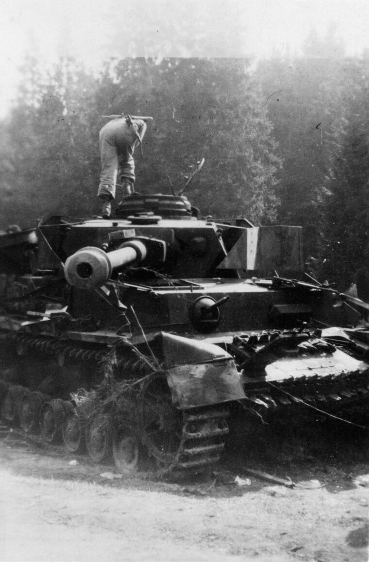 An American peers into the hatch of a knocked-out Panzerkampfwagen Tiger Ausf. E (Tiger I) heavy tank in the Harz Mountains near the town of Schierke, April 29, 1945.