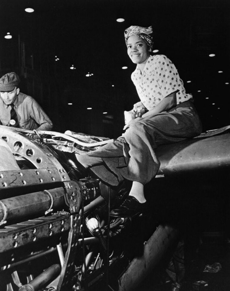 An African American woman is photographed working in an aircraft factory. Wartime job opportunities did much to improve the status of minorities.