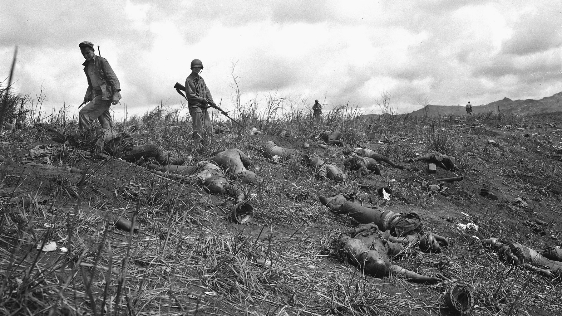 American Marines survey the death toll following one of several Japanese banzai charges on Guam. Although the Japanese charges sometimes temporarily penetrated American lines and inflicted casualties, the result was predictable. Japanese losses were heavy and irreplaceable.