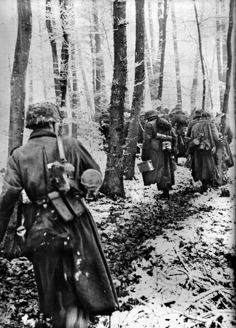 Members of a Volksgrenadier unit move through a Luxembourg forest during the opening hours of their surprise Ardennes Offensive, December 16, 1944.