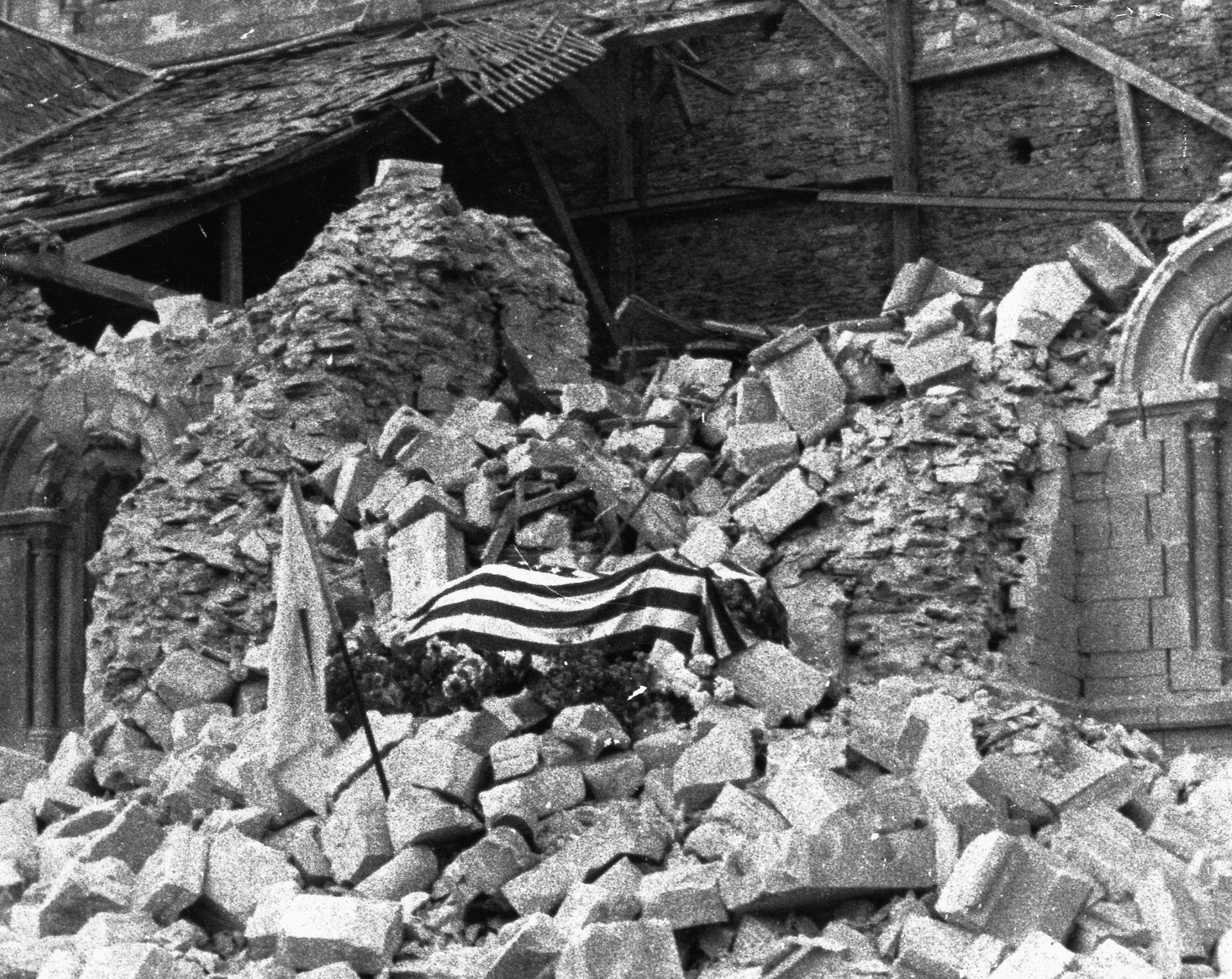 His body draped in an American flag, Major Thomas D. Howie lies in state atop the rubble of a blasted church in the heart of St. Lô.