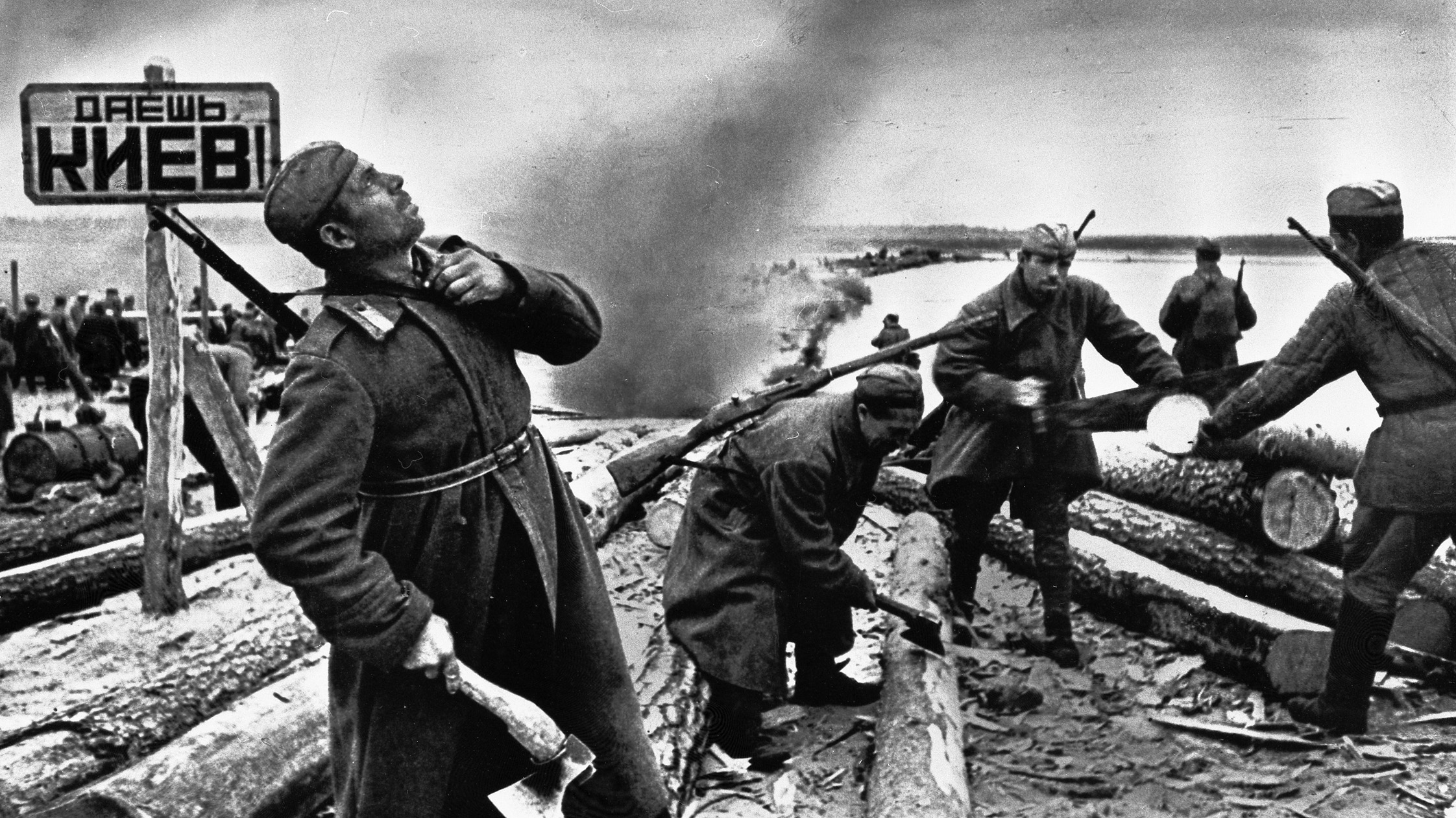 During the fighting around the Ukrainian capital of Kiev, Soviet sappers establish a crossing of the Dnepr River. One of the sappers is looking skyward in response to noise from approaching aircraft.