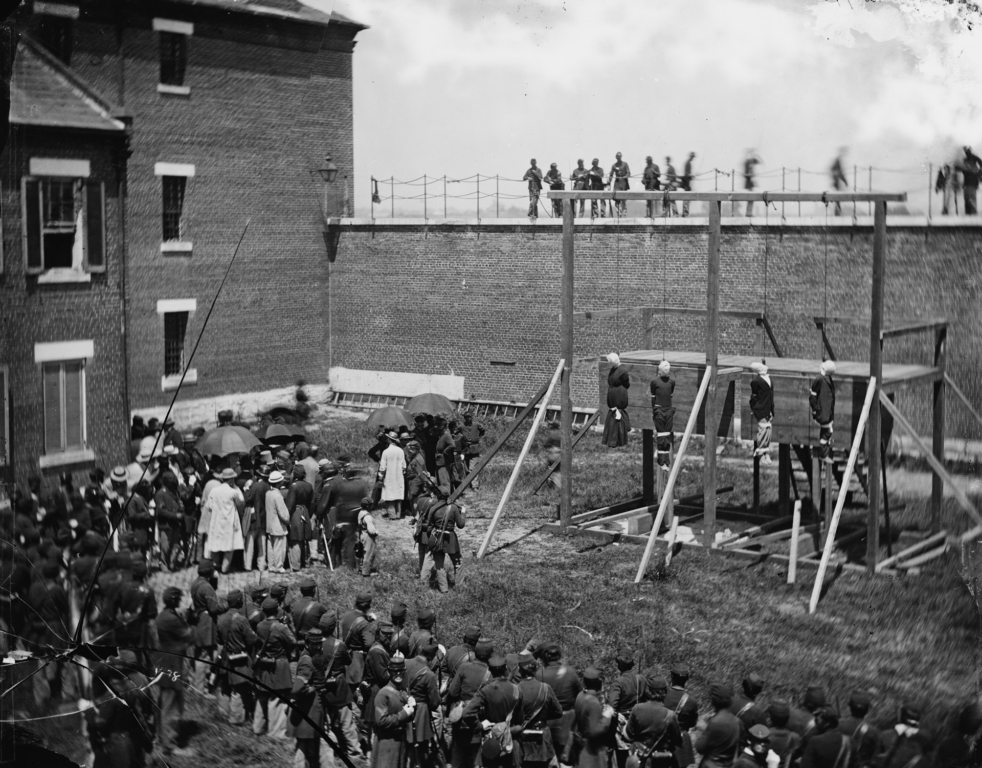 Alexander Gardner’s photo of the executed Lincoln conspirators at Washington’s Old Penitentiary on July 7, 1865. Hanging left to right with their heads covered and arms and legs bound are Mary Surratt, Lewis Paine, David Herold, and George Atzerodt.