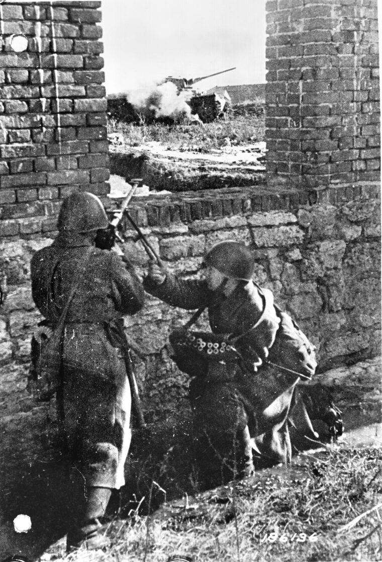 Soviet soldiers fire a PTRD-41 antitank rifle from a protected position at a German tank on the Eastern Front in 1943. Although not powerful enough to penetrate the thick frontal armor of German tanks, the rifles were capable of breaking through their thinner side and rear armor.