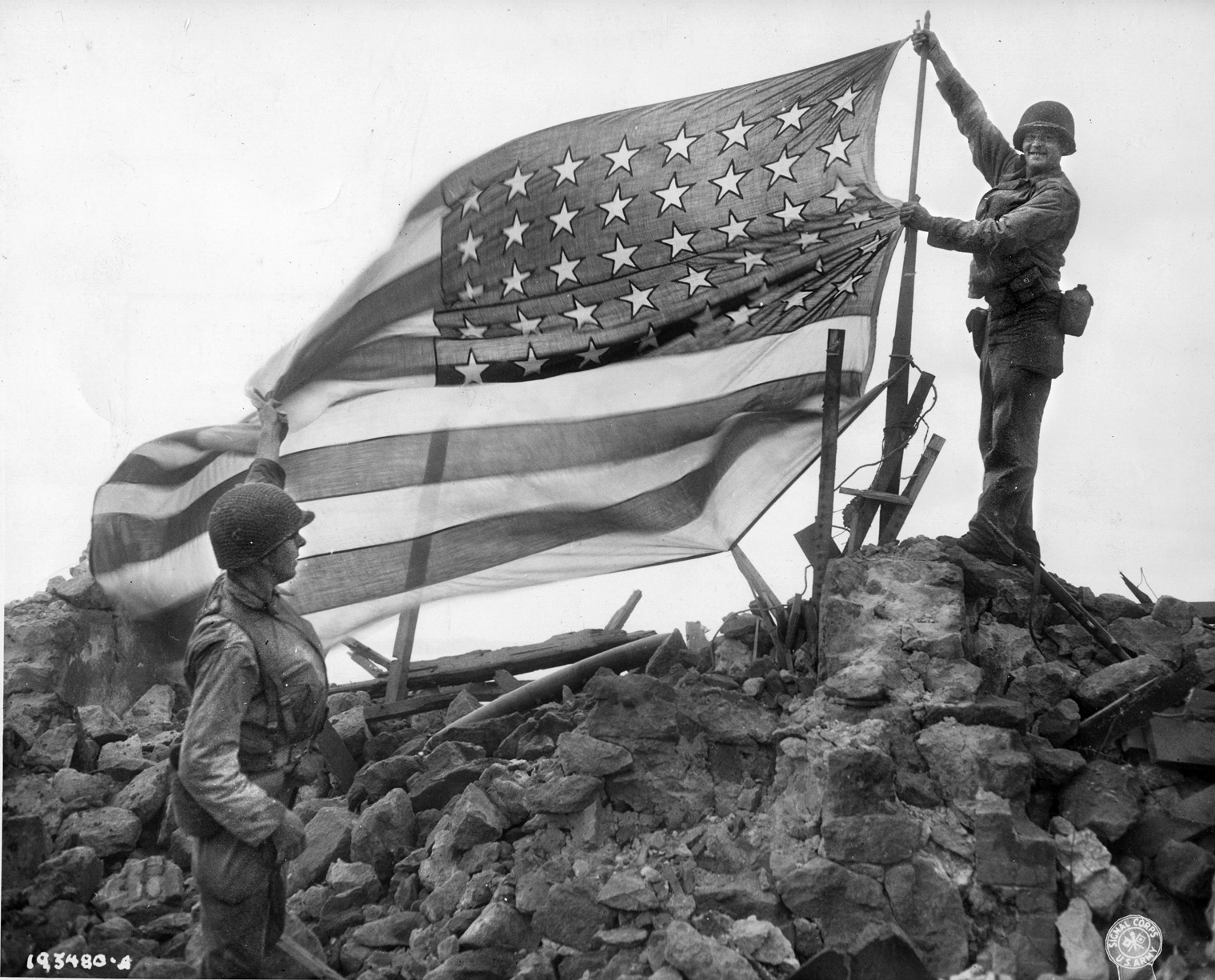 After the German garrison on the island of Cezembre has surrendered, soldiers of the U.S. 83rd Infantry Division raise the American flag in triumph. The island is located near the French city of St. Malo, where troops of the 83rd Division were also engaged.