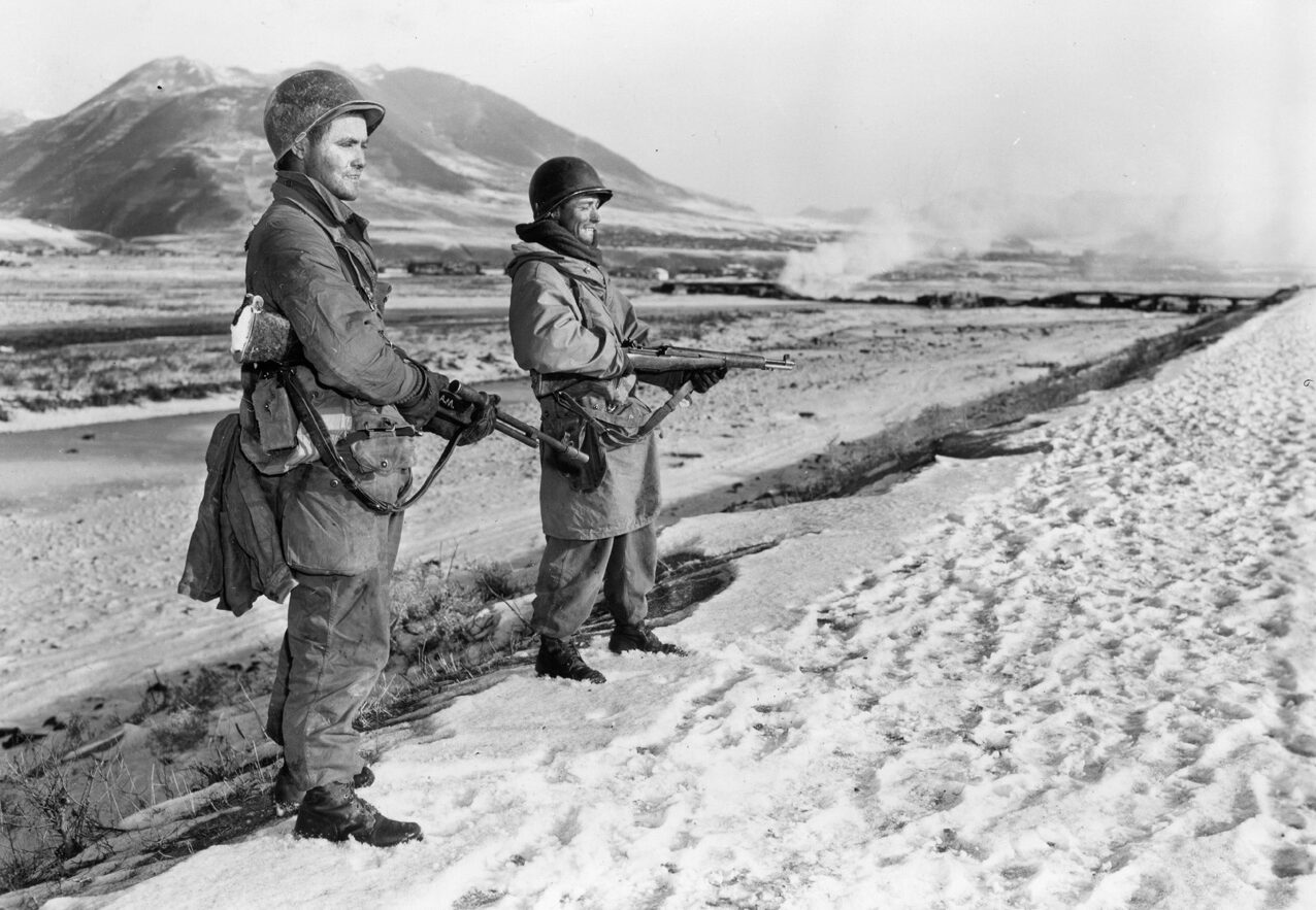Two soldiers of the U.S. Army 7th Infantry Division patrol the banks of the Yalu River at the Chinese border.