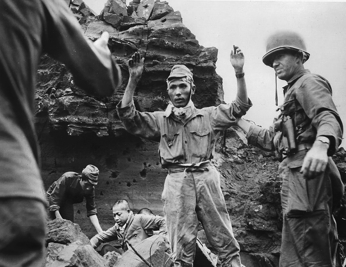 Dazed and shell-shocked, the first of 21 Japanese to emerge from a cave surrender in March 1945. Out of a garrison of 21,000, only about 200 Japanese were taken prisoner.