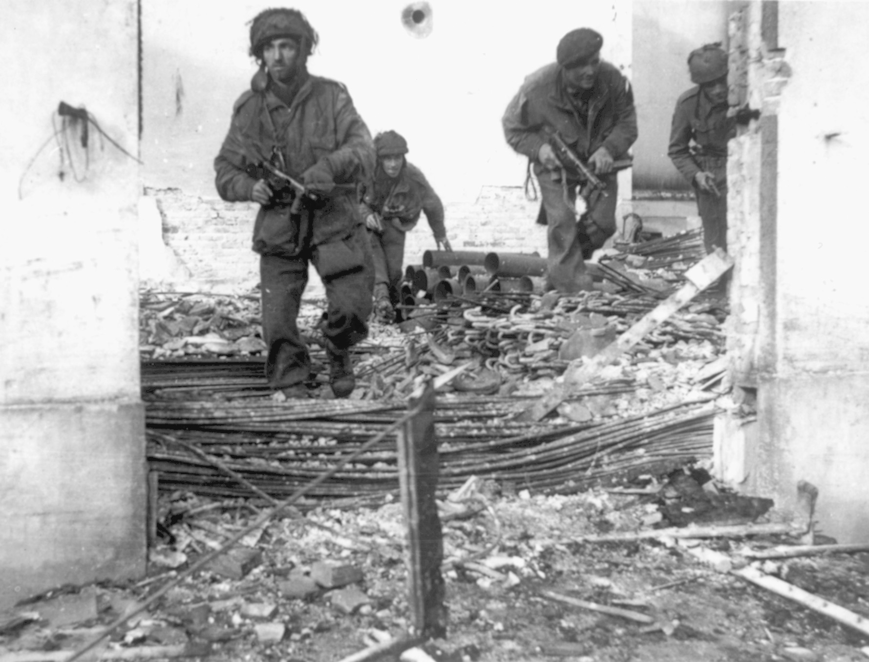 The British patrol through ruined homes in Oosterbeek near Arnhem. By the 25th of September when this picture was taken, the British perimeter was small. 