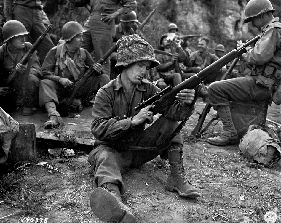 A GI with the 36th Infantry Division cleans his M1903 Springfield, equipped with sniper scope, during the Italian campaign of 1943.