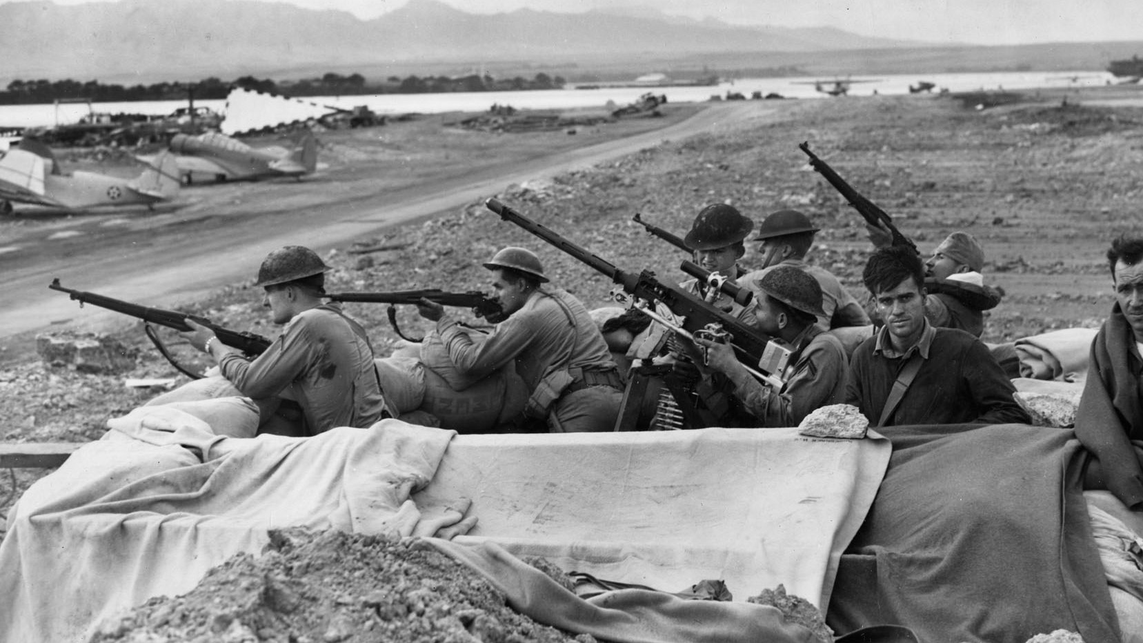 In the aftermath of the Pearl Harbor attack, U.S. Marines and soldiers stationed across Oahu were nervous and often fired at anything remotely suspicious. These troops man a sandbag gun emplacement adjacent to an airfield, their rifles and machine gun at the ready.