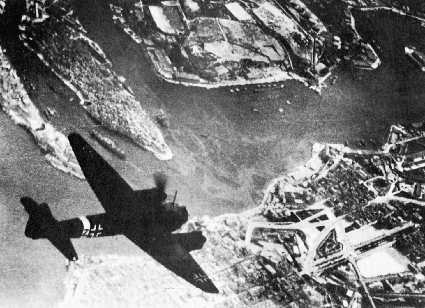 A German Ju-88 flies over the Maltese harbor at Valletta on a bombing mission.