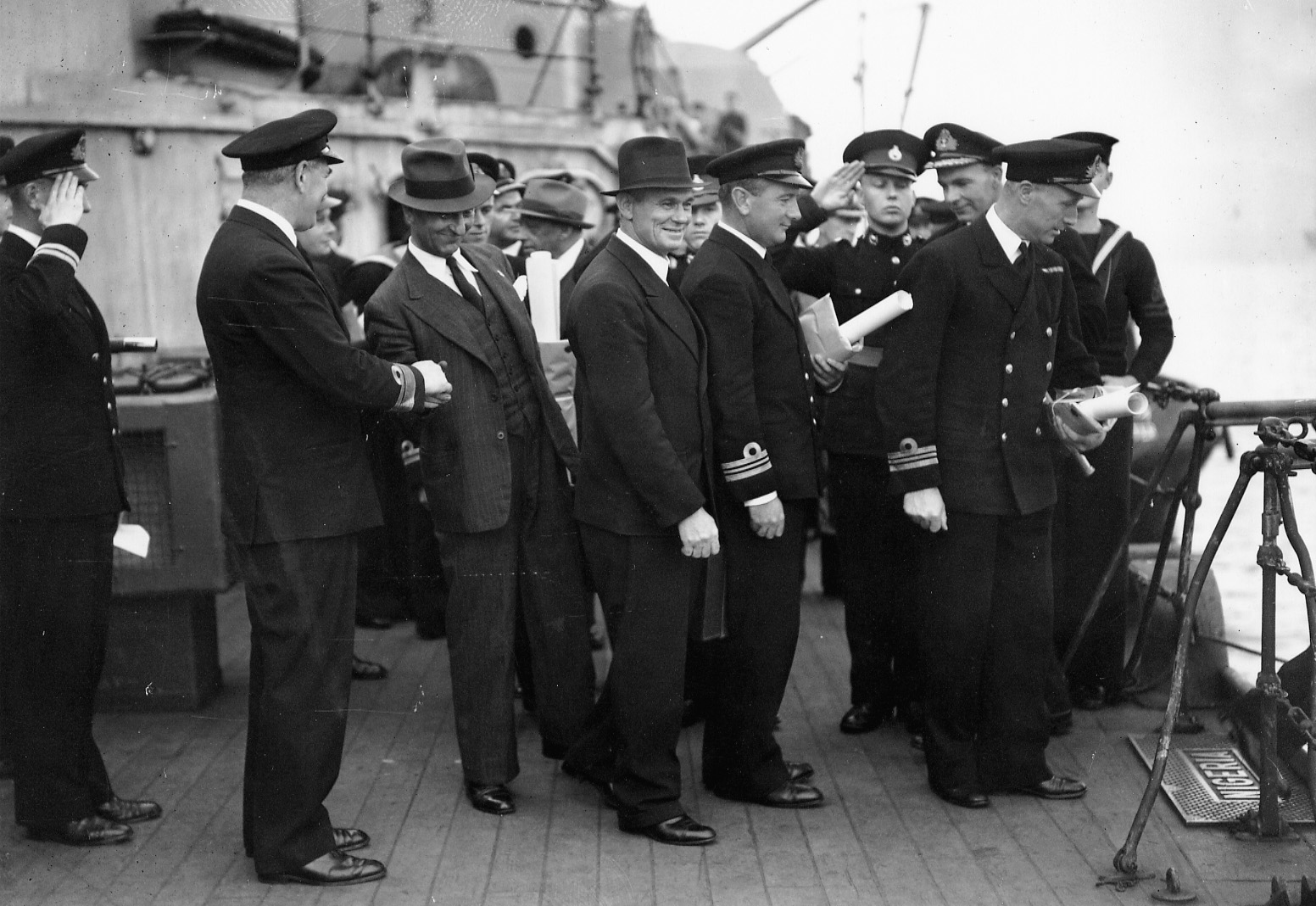 Shortly before setting sail, officers take part in a conference regarding Operation Pedestal. Rear Adm. Sir Harold Burrough (second to left) can be seen shaking hands with Captain Dudley Mason of the Ohio.