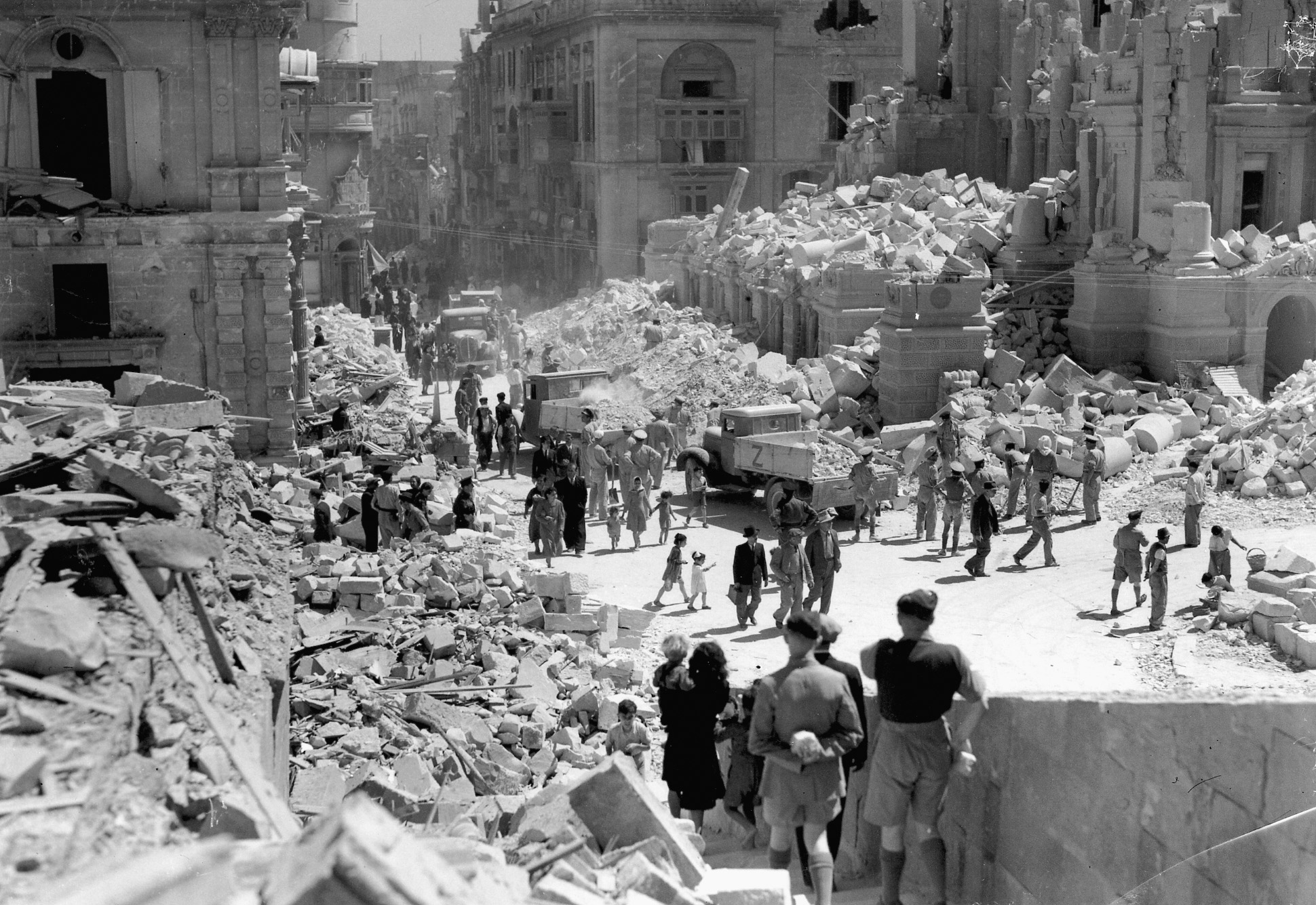 Civilians wander about streets marred by the German bombing campaign. At times, the forces available to defend Malta against air attacks dwindled to virtually nothing. 