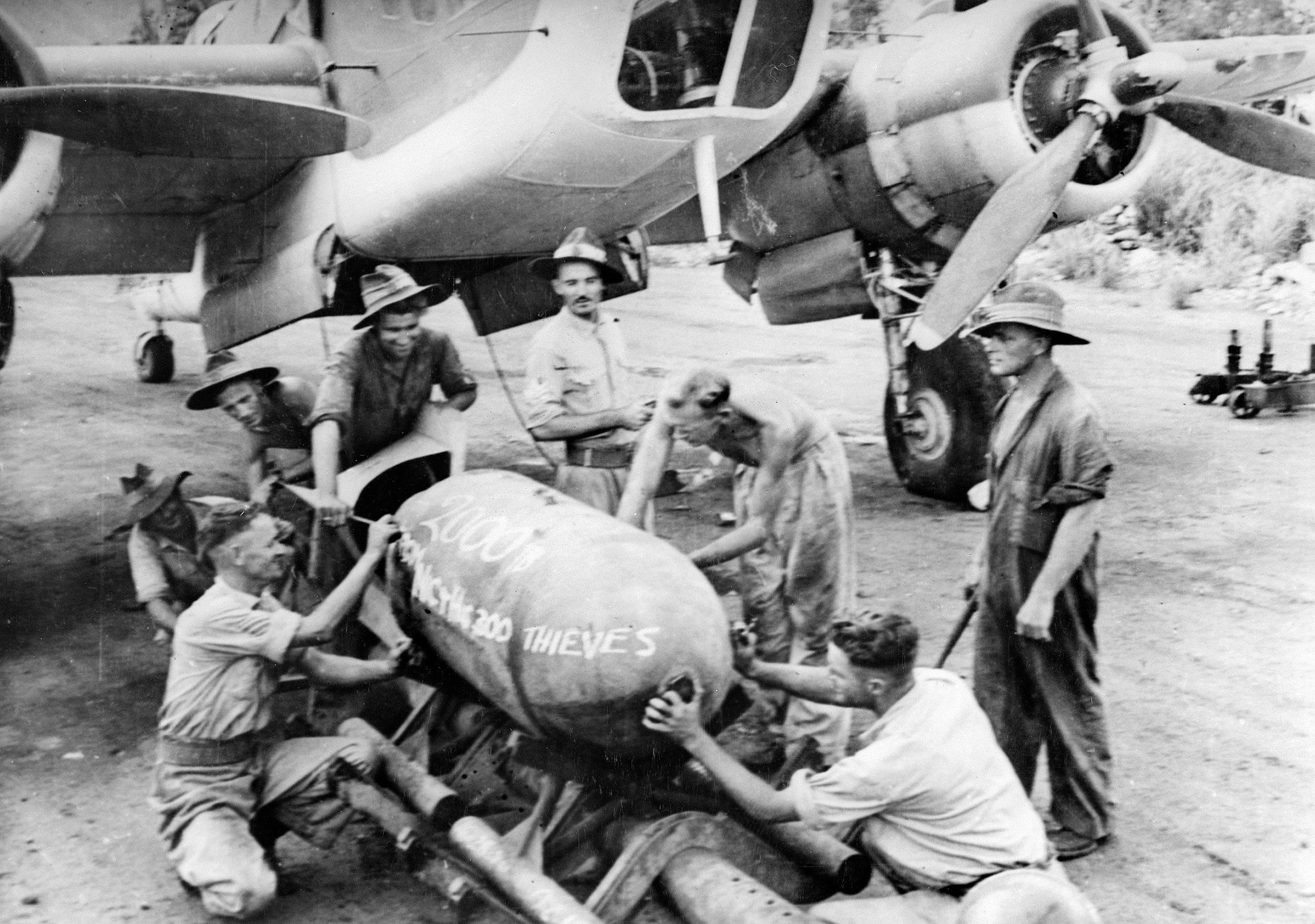 Members of an RAAF squadron leave their mark on a 2000-pound “daisy cutter” to be dropped on the Lakunai Aerodome in Rabaul.