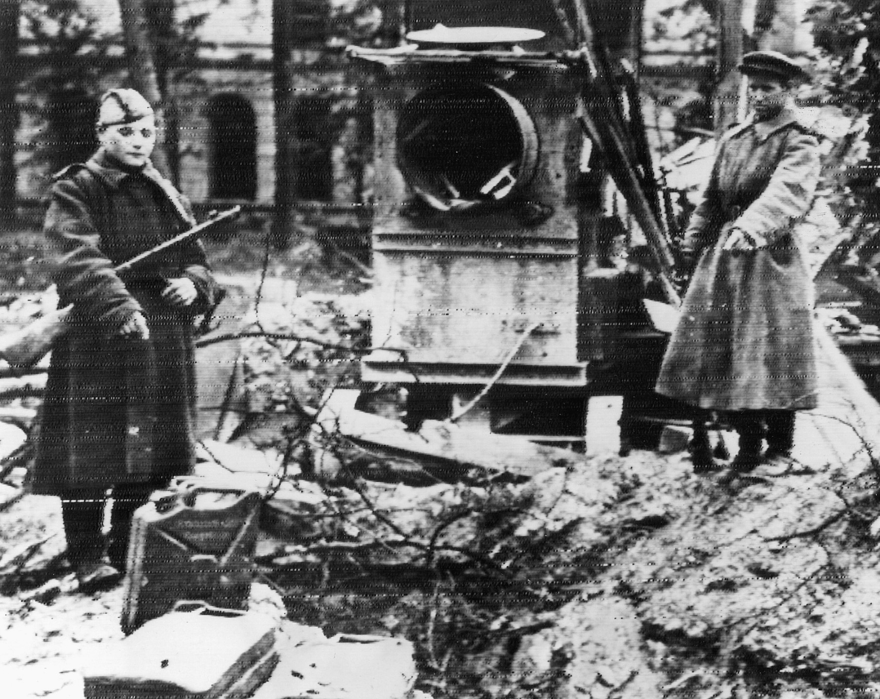 Two Russian soldiers motion towards the place in the Führerbunker garden where the bodies of Hitler and Eva Braun were doused with gasoline and set afire.