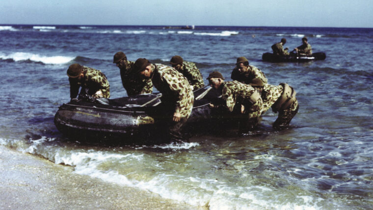 Donning camouflage, a team of OSS operatives lands ashore. Despite initial skepticism, the OSS more than proved its worth during numerous operations in Italy and North Africa.