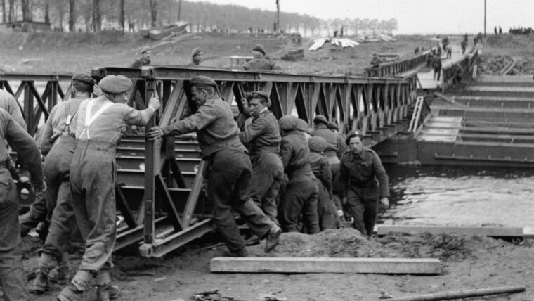 British soldiers put their backs into moving pieces of a Bailey Bridge built on pontoons over the Weser River in Germany, 1945.
