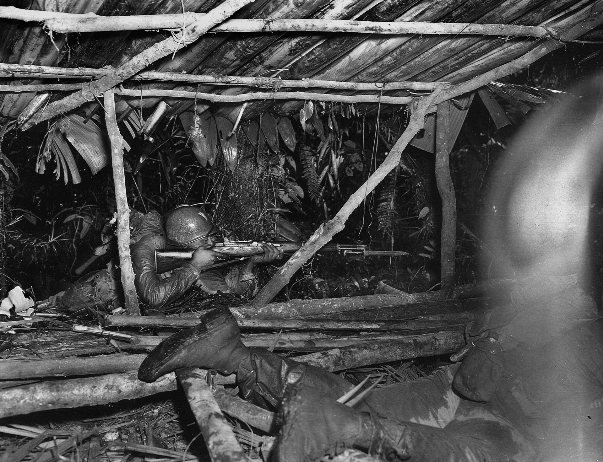 A 25th Infantry Regiment soldier, supporting the 23rd (Americal) Infantry Division, takes aim at Japanese troops in an enemy bivouac area on Bougainville, April 6, 1944.