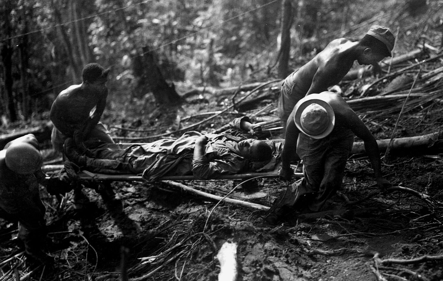 Litter bearers of Company K, 25th Regiment, 93rd Division struggle up Hill 290 on Bougainville with a wounded comrade during fighting on April 7, 1944.