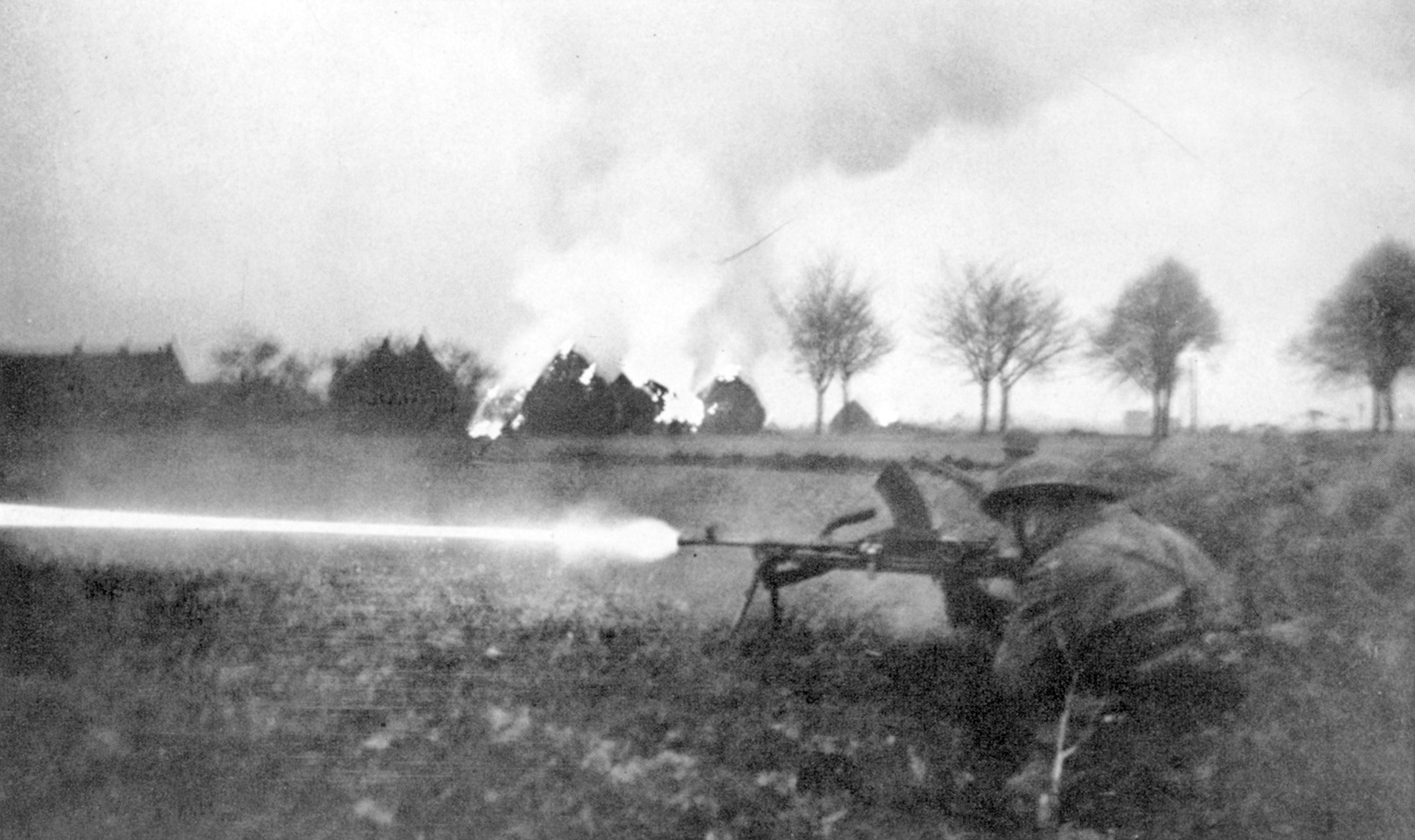 A British soldier fires a Bren gun in an open field near Arnhem as haystacks blaze in the background. Less than 2,000 members of the British 1st Airborne Division escaped capture or death during Operation Market-Garden. Relief forces failed to arrive in time to secure the bridge across the Lower Rhine.