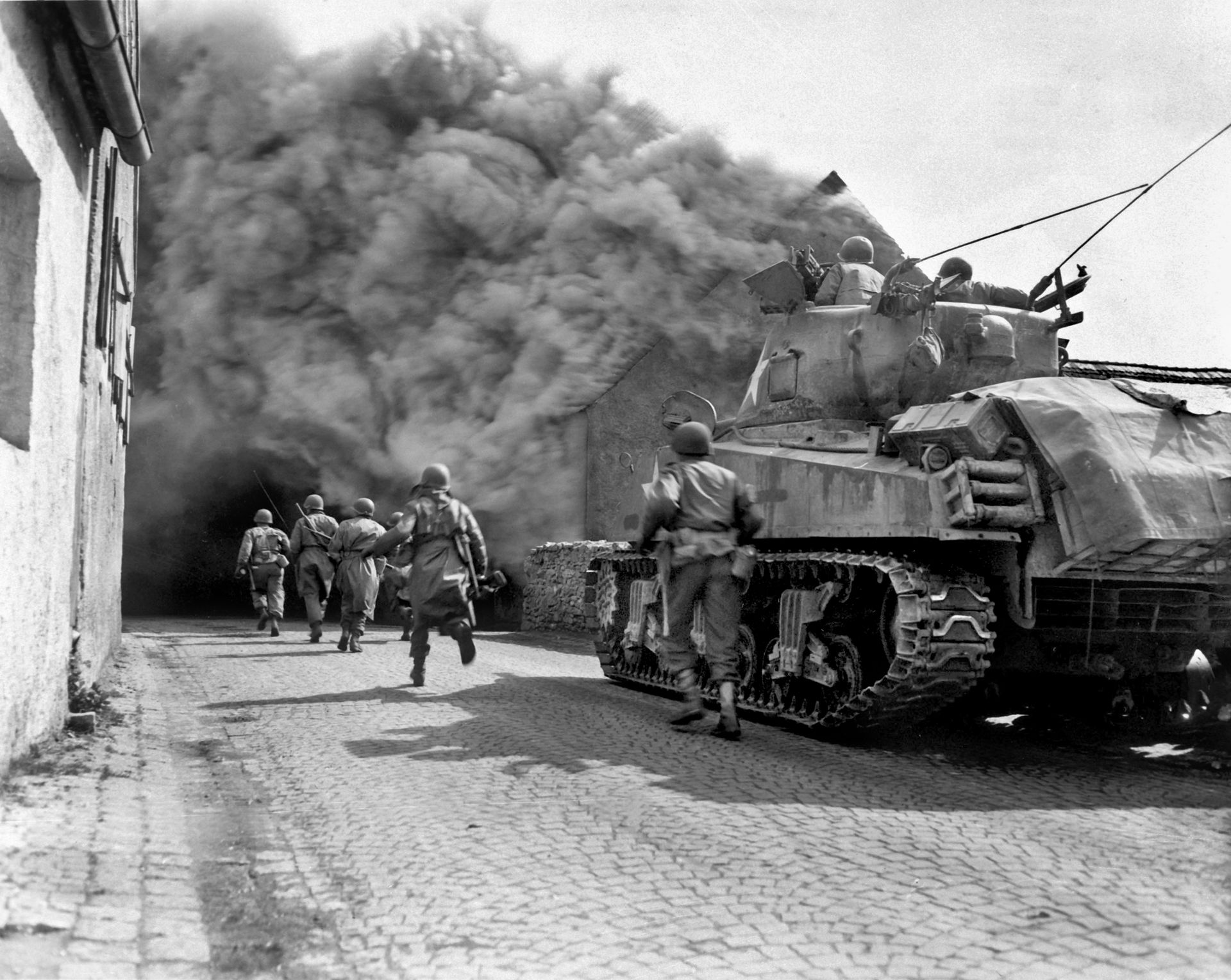 A U.S. tank helps clear enemy troops from a German town. On April 4 the 5th Armored Division crossed the Weser River after waiting for XIII Corps infantry to catch up.