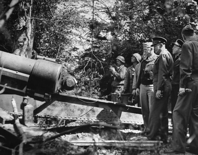 General Henry “Hap” Arnold, chief of the U.S. Army Air Forces, and Supreme Allied Commander Dwight Eisenhower inspect a 155mm German gun discovered hidden in the Normandy woods.