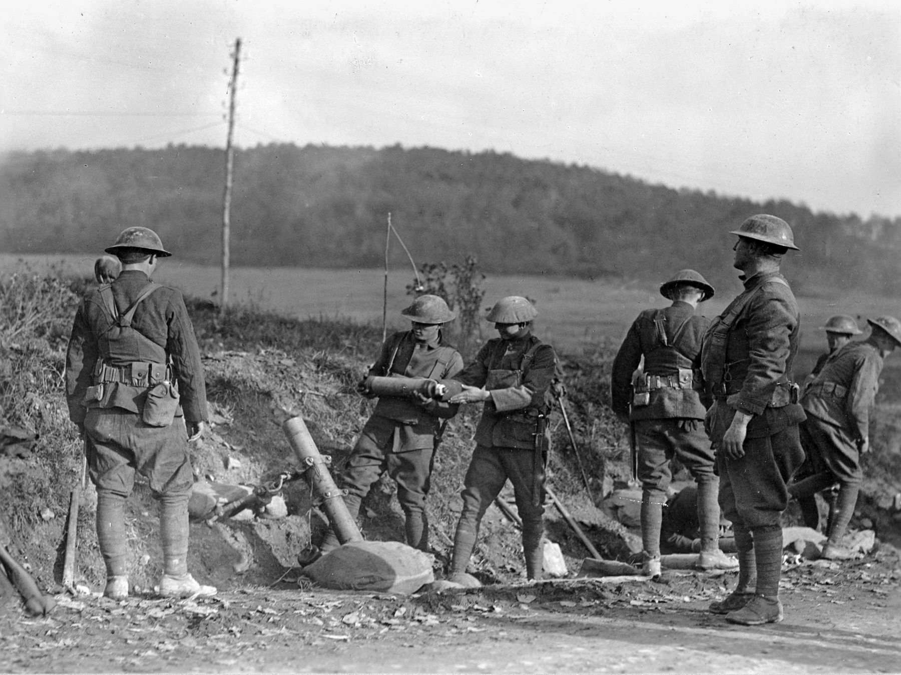 Members of a trench mortar battery in Company C, 1st Gas Regiment, 80th Division, load and fire phosphorous and Thermite shells near Le Neufour, France, on October 27, 1918.