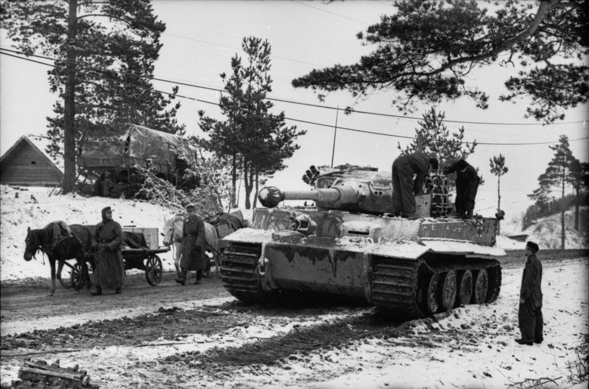 A German panzer crew works on its Tiger I during the long Russian winter as German infantry marches past with a horse-drawn vehicle. By the war's end more than one million horses were still hauling German personnel, artillery, and ammunition.
