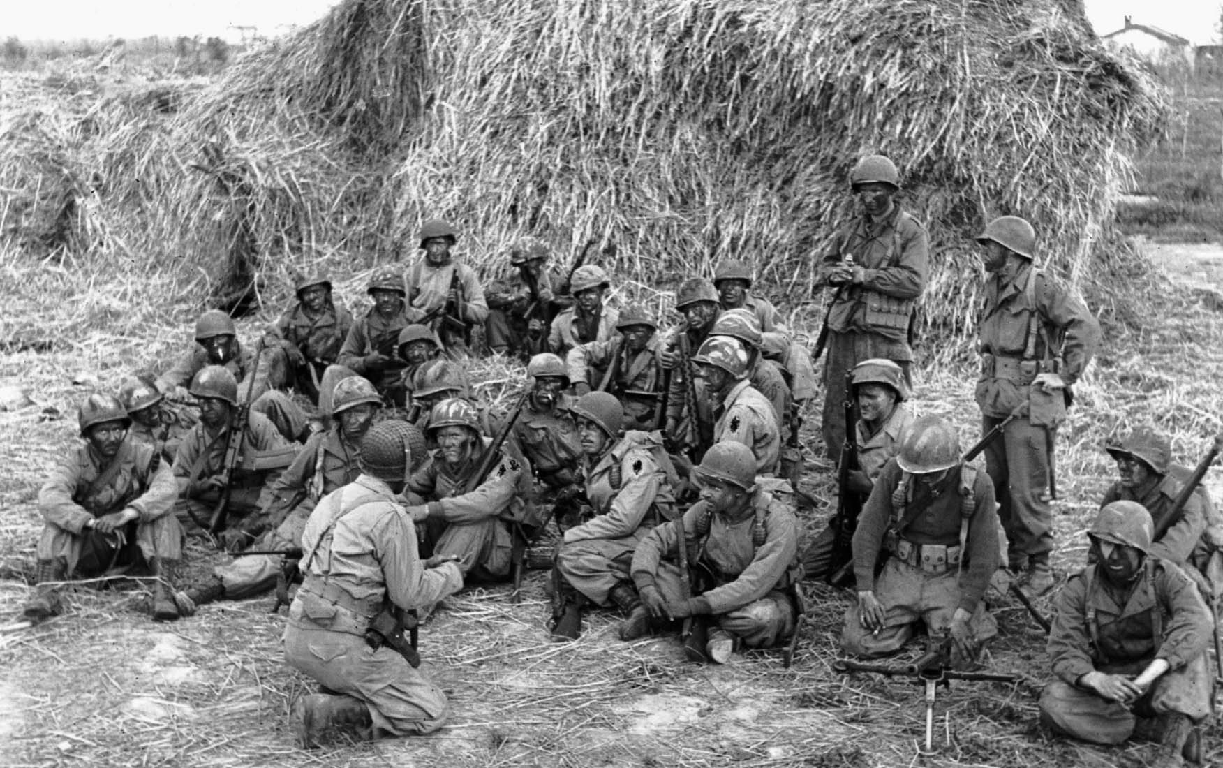 After battling for weeks on the Winter Line, the 1st SSF was moved to bolster the Anzio beachhead. A night patrol, with soldiers’ faces blackened, is being briefed behind an Italian haystack before moving out, April 20, 1944.