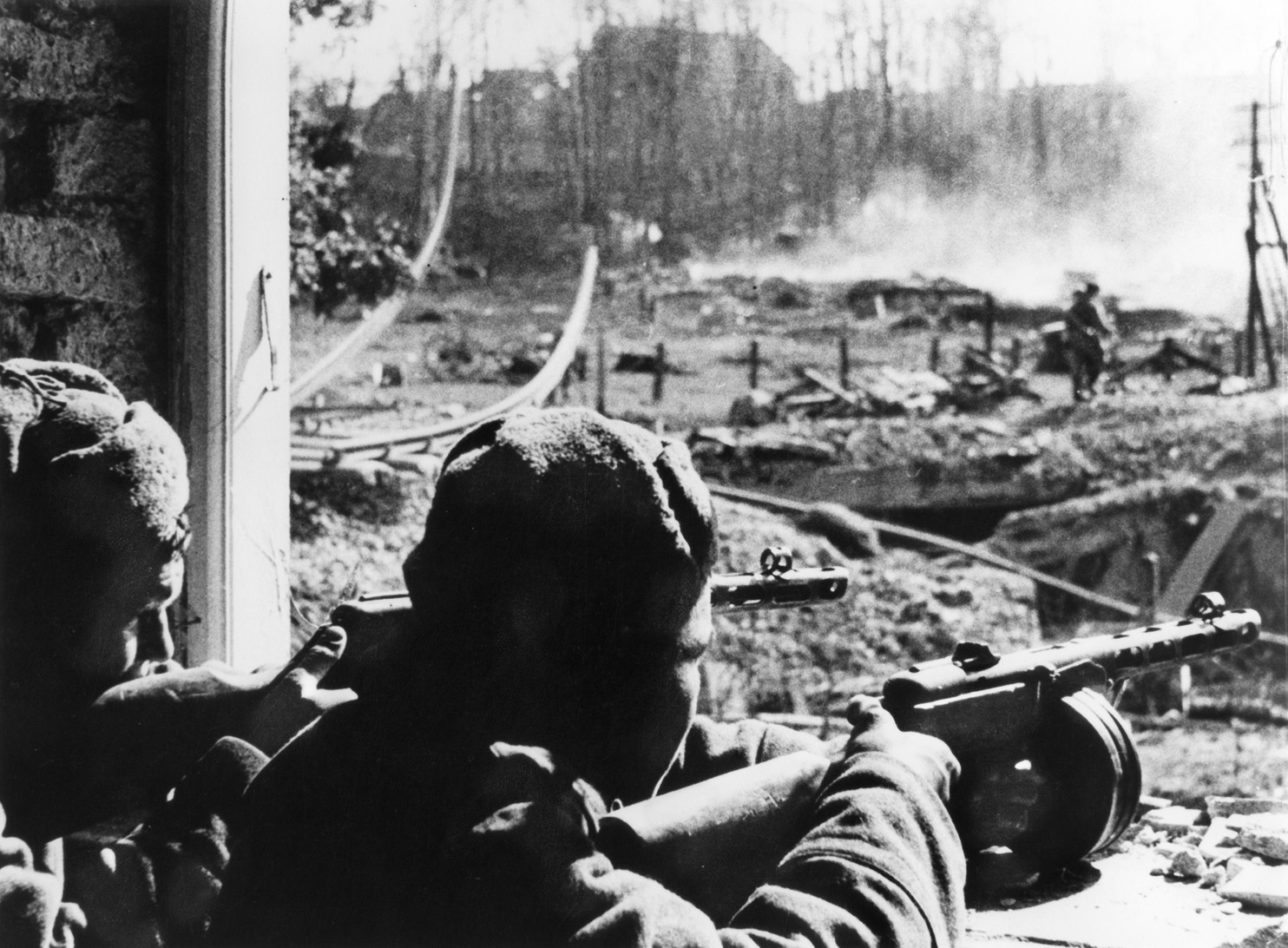 A pair of Red Army soldiers aims their automatic weapons at German positions while awaiting orders to move forward during fighting in the suburbs of Königsberg in April 1945.