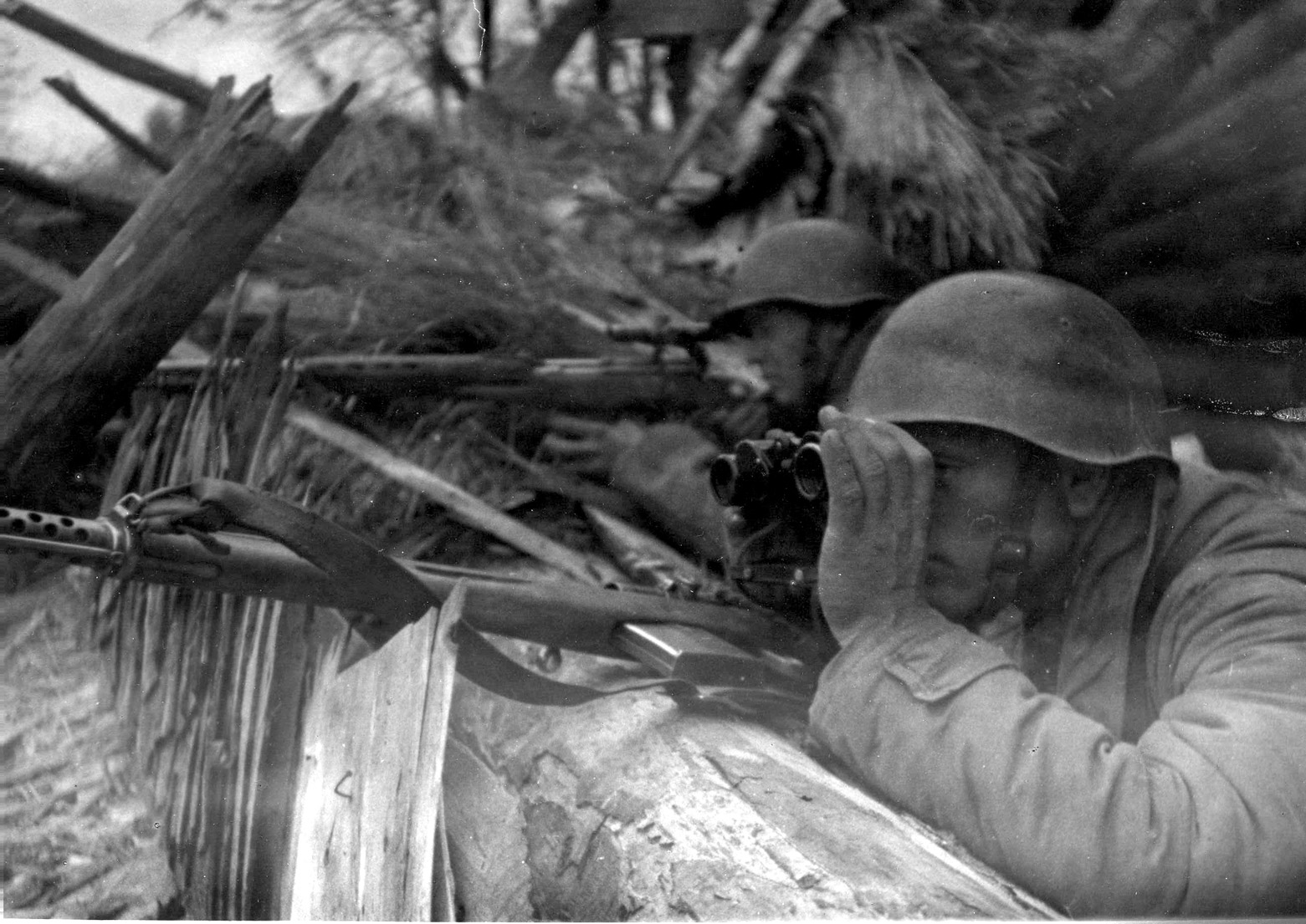 Sergeant Fedor Pekov takes aim at his vantage point while Vladimir Mikheyev uses his binoculars to scan for the enemy. Much of sniping was a question of waiting, sometimes for days. 