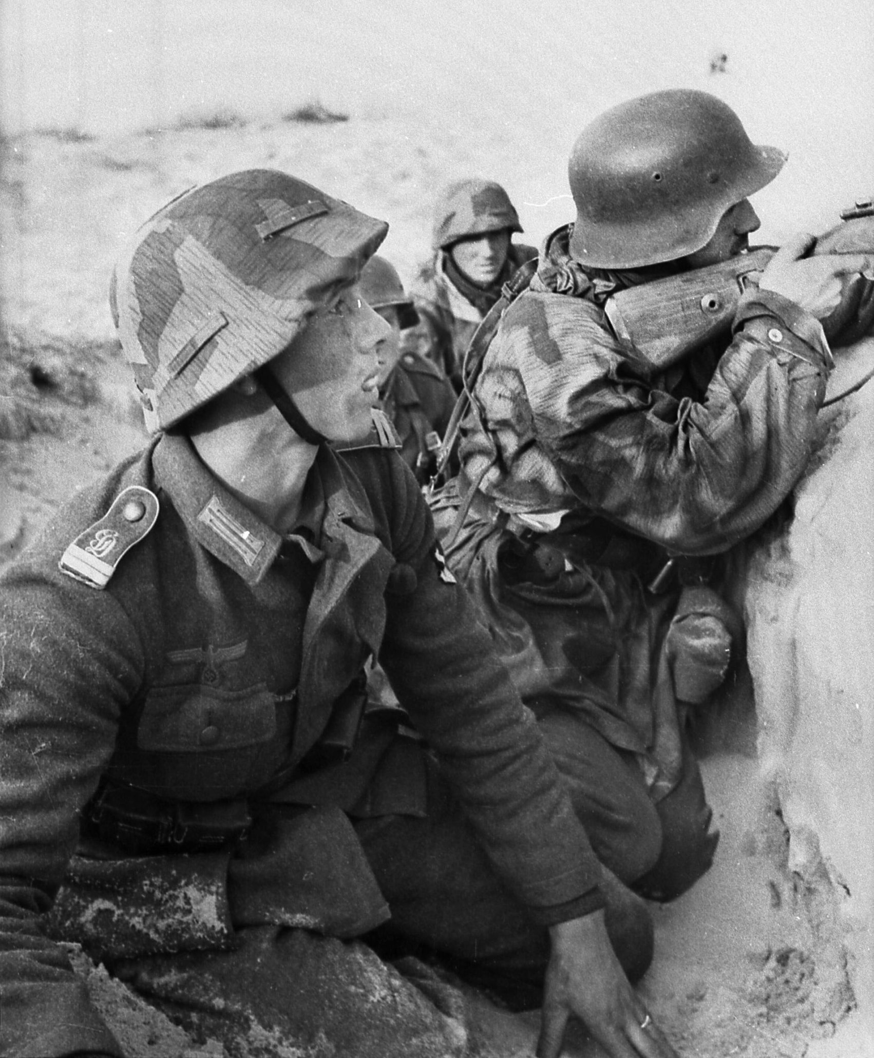SS soldiers of the German Infantry Regiment Grossdeutschland peer apprehensively over the top of a ditch that provides some cover against enemy fire. These troops were assigned to Army Group Center in the  summer of 1941. During those long days, the Red Army won its first major victory of the “Great Patriotic War” around Yelnya.