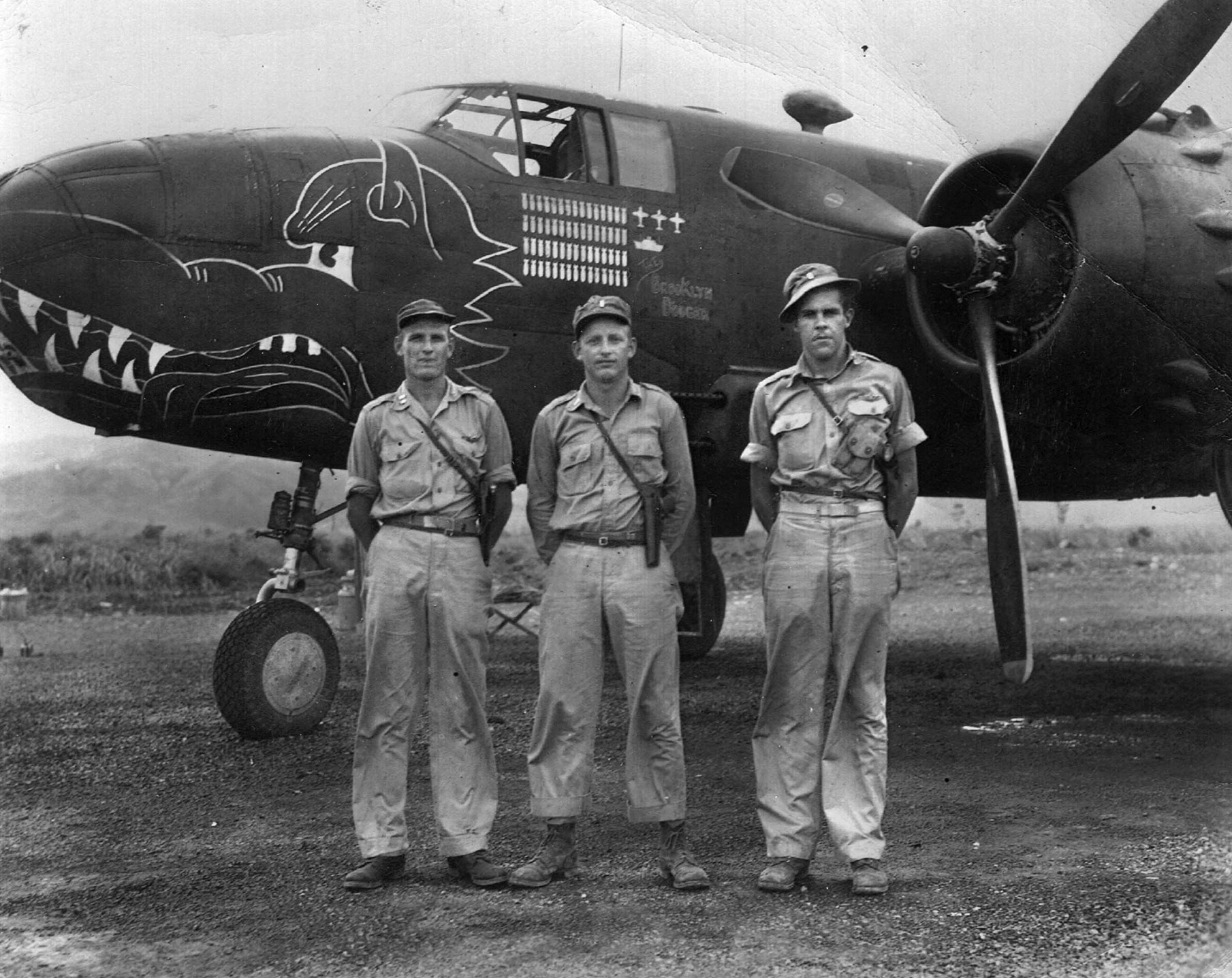 After their narrow escape from death in the Kavieng raid of February 15, 1944, survivors from the B-25 medium bomber nicknamed Pissonit pose for a photographer. The trio includes, left to right, Lieutenant Eugene Benson, Lieutenant Hollie Rushing, and Lieutenant William J. Smith.