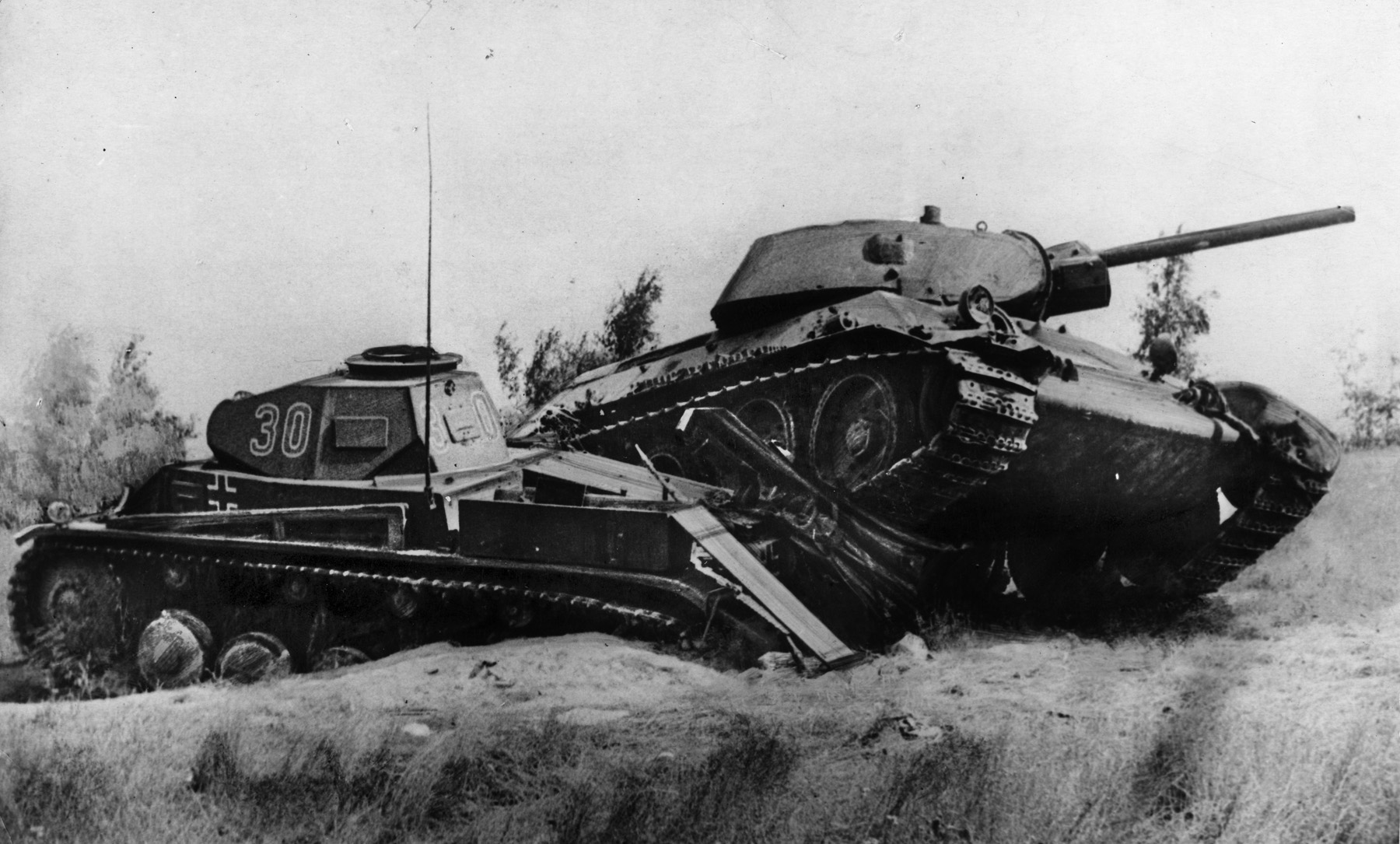 In this dramatic photograph taken in August 1941, a Soviet T-35 tank rolls across the flank of a disabled German tank somewhere in Russia. Soviet armored innovation produced the legendary T-34 medium tank, which helped turn the tide of the war in the East.