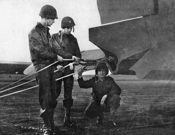 C-47 crew members inspect tow ropes on their plane