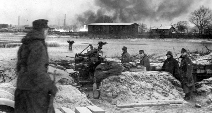 This forlorn view across the Warthe River depicts the burning town of Neustadt while German forces prepare to attempt a breakout from Soviet encirclement against orders from Adolf Hitler.