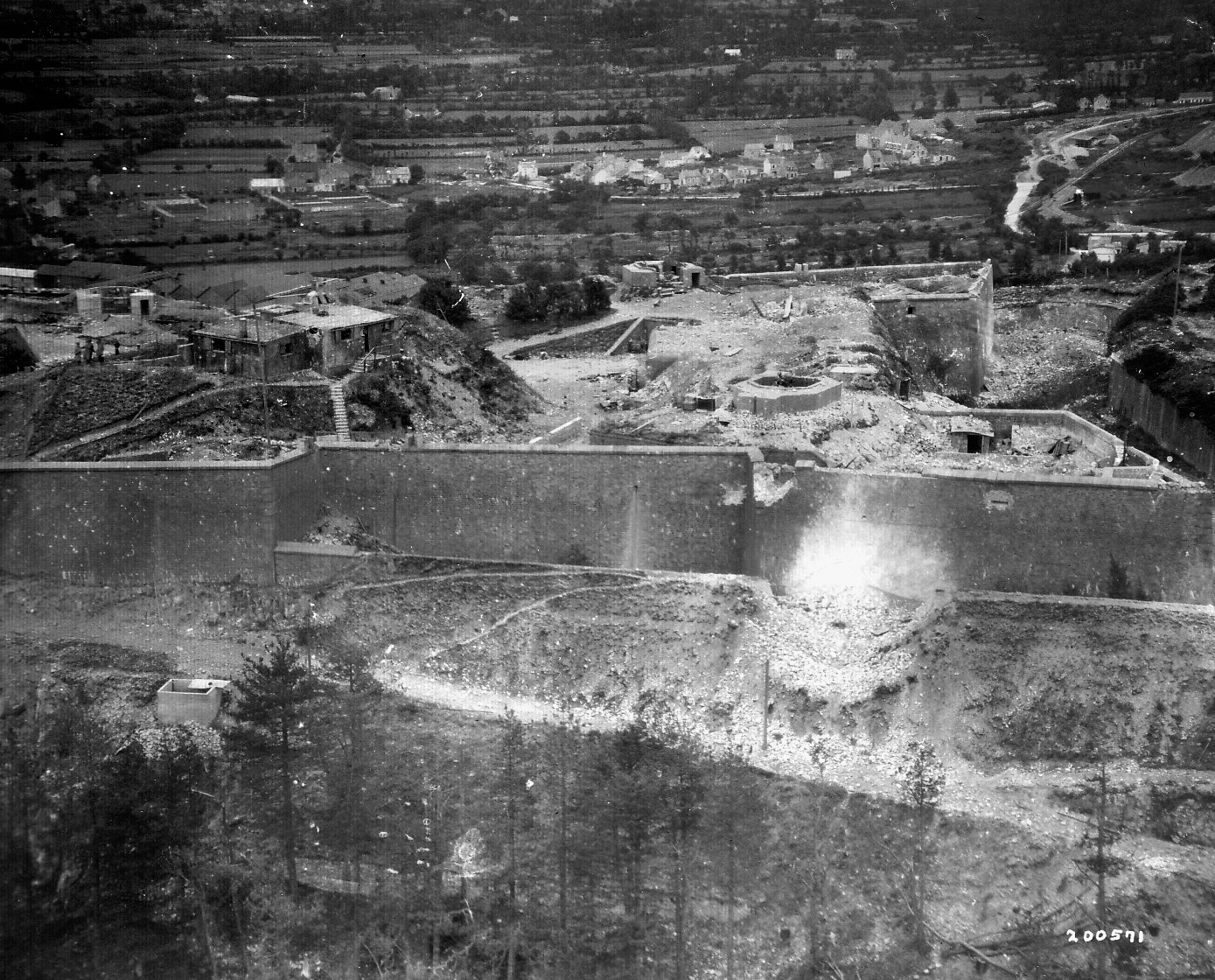 A German fortification located on a hill near the inner harbor of Cherbourg is shown under attack by American forces. The city was eventually surrendered by its defenders, but the port was unusable for some time.