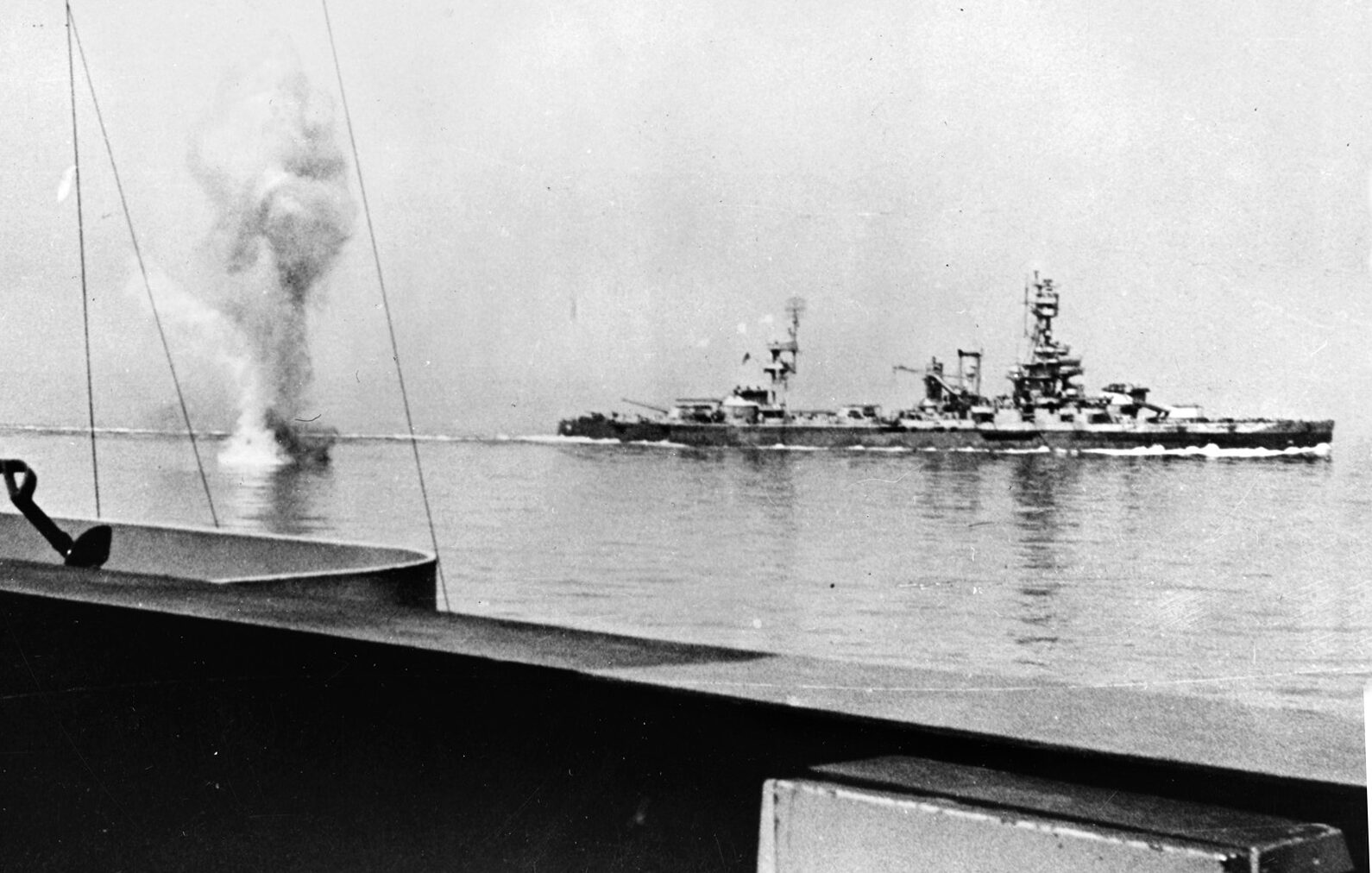 During the fight for Cherbourg, U.S. Navy battleships Arkansas and Texas duel with heavy German shore batteries. The water plumes of German shells are visible in this image at left. 