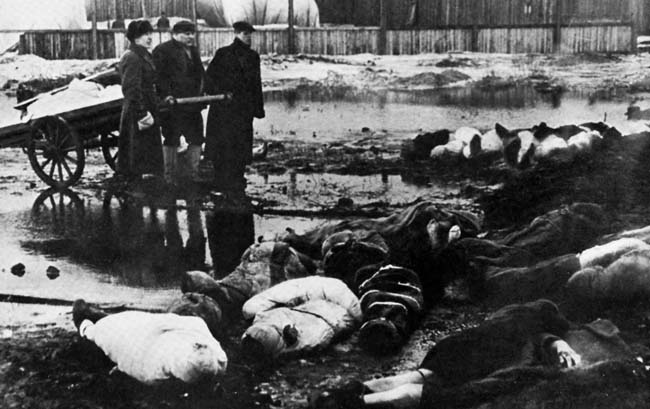 Погребальная бригада смотрит на груду завернутых трупов в Ленинграде. 
Горожане были настолько ослаблены голодом, что многим не хватило сил даже убрать мертвых. 
Многие горожане прибегли к каннибализму.