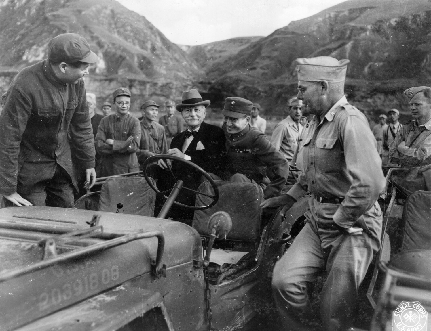 During a meeting in China in 1945, Communist leader Mao Tse-tung climbs aboard a Jeep that is carrying U.S. Ambassador Patrick Hurley and American Colonel I.V. Yeaton. 