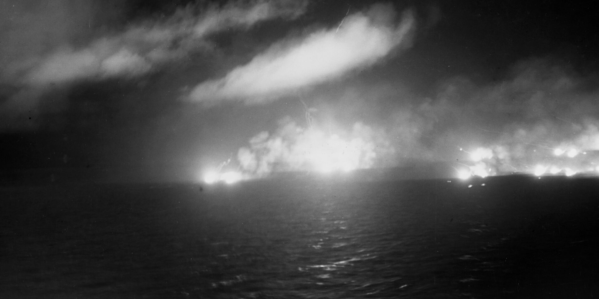 U.S. Navy warships, including several battleships that were survivors of the infamous Pearl Harbor attack three years earlier, rained heavy-caliber shells on the hapless Japanese vessels that ventured into Surigao Strait. In this image, the flashes from the guns of American cruisers light up the night sky.