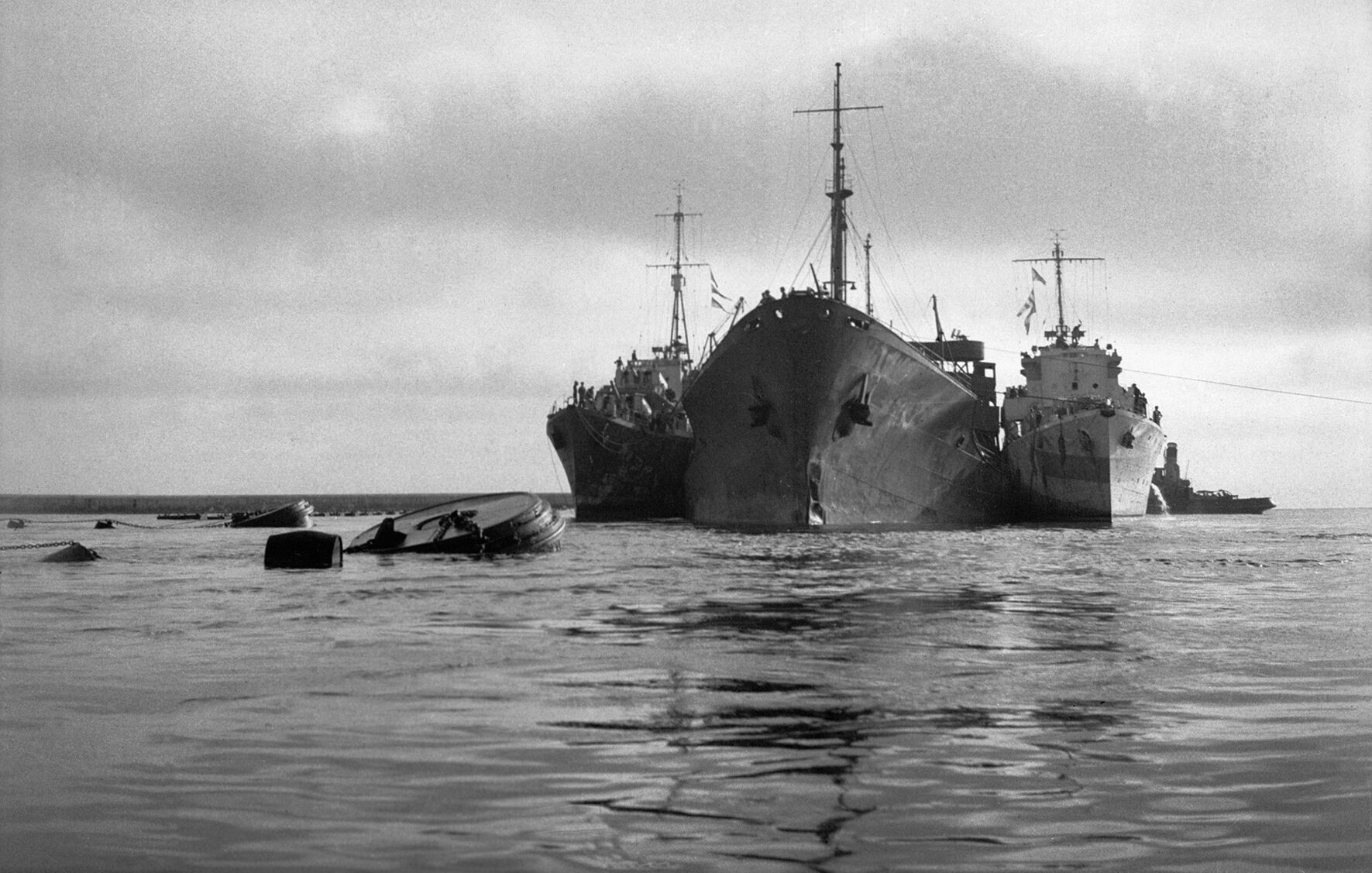 American oil tanker Ohio is supported by two Royal Navy destroyers as it approaches Malta following epic voyage through the Mediterranean, August 1942. Having surviving torpedos, aerial bombardment, and a fire, the Ohio, manned by a British crew, was called “the ship that wouldn’t die.”