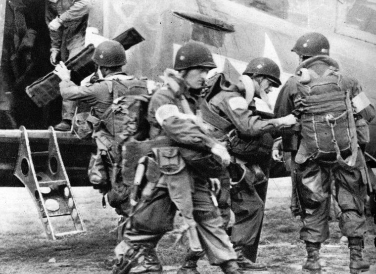 Men of the 82nd Airborne Division check each other’s gear before loading onto a Carrier Group C-47 on June 5, 1944.